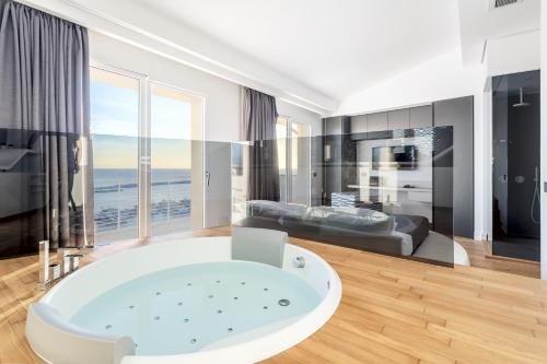 baño grande con bañera y sofá en Hibrido Boutique Hotel & Spa, en Sciacca