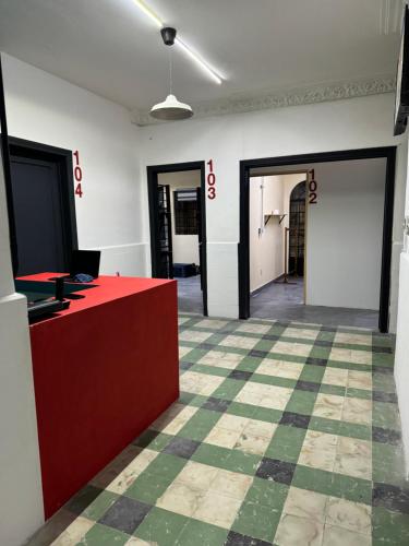 una oficina con un mostrador rojo y un suelo a cuadros en Hostal YOA 101, en Ciudad de México