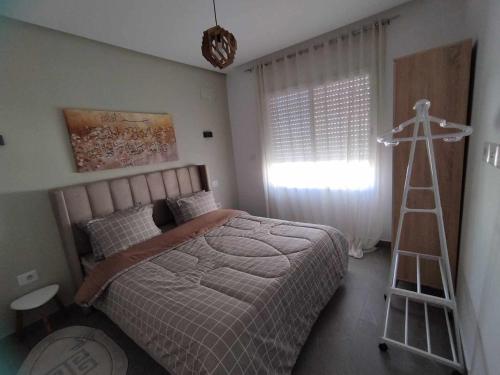 Un dormitorio con una cama y una escalera. en Coquette Appartement, en Boumhel El Bassatine