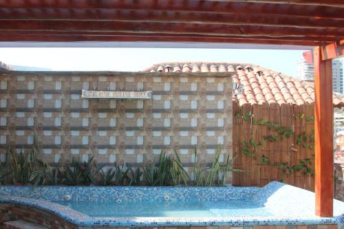 a swimming pool in front of a brick wall at Hotel Rodadero Dorado in Santa Marta