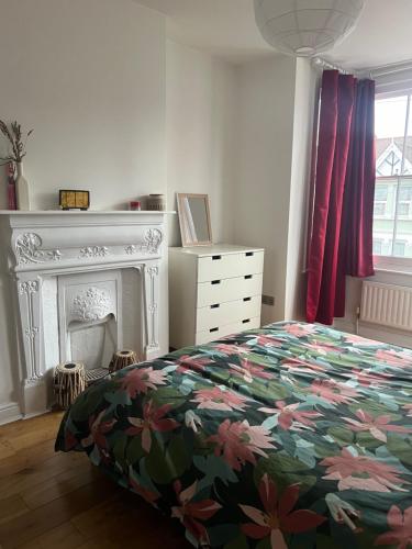 a bedroom with a bed and a fireplace at Ilford Hidden Gem in Ilford