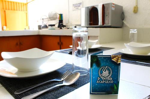 a table with a plate and spoon and a box of milk at D'Cesar Hotel Acapulco in Acapulco