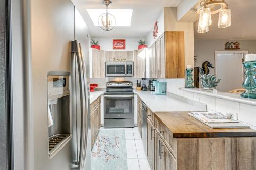 a kitchen with white counter tops and a refrigerator at Port Charlotte Paradise with Private Outdoor Oasis! in Port Charlotte