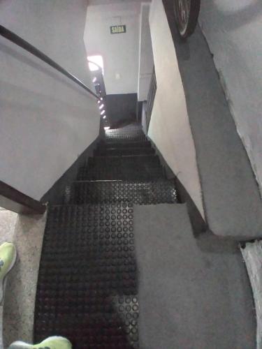 an escalator in a building with black stairs at Hospedagem domiciliar casa do Jorge Rua 44 Nossa Senhora da Angústia Itapuã in Salvador