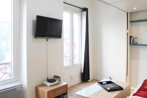 Modern cocoon near Belleville في باريس: غرفة معيشة مع تلفزيون بشاشة مسطحة على الحائط