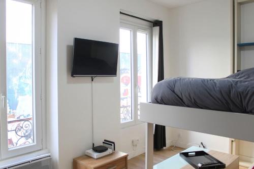 - une chambre avec des lits superposés et une télévision à écran plat dans l'établissement Modern cocoon near Belleville, à Paris