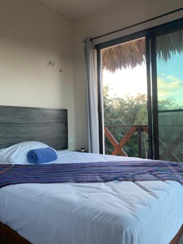 a bedroom with a bed and a large window at Casa Delfín Tulum in Macario Gomez