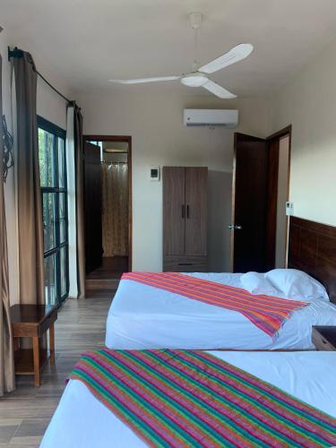 a hotel room with two beds and a window at Casa Delfín Tulum in Macario Gomez