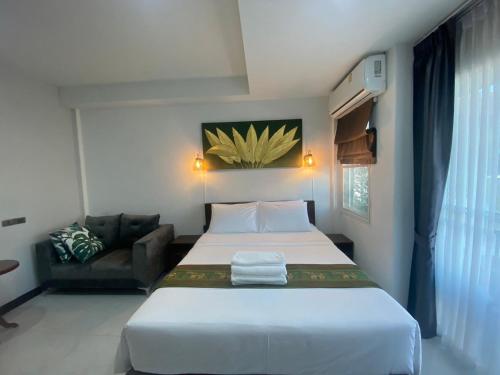 a bedroom with a large white bed and a couch at Lemon Guesthouse in Chiang Mai