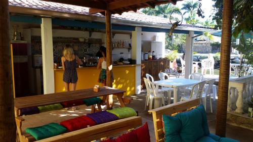 a woman standing in a kitchen with a counter at Maracujá Hostel in Paraty