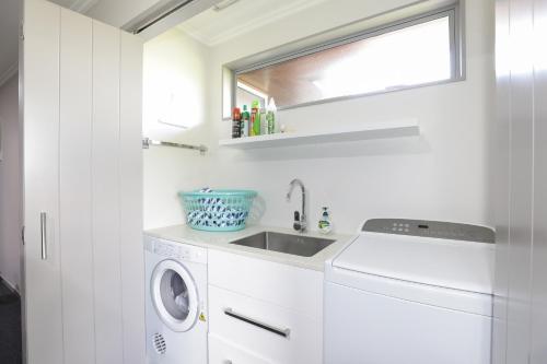 a white laundry room with a sink and a washing machine at Eagles Nest - Kinloch in Kinloch