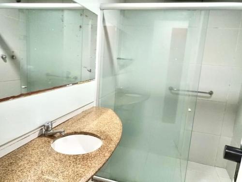 a bathroom with a sink and a glass shower at Victory Flat in João Pessoa