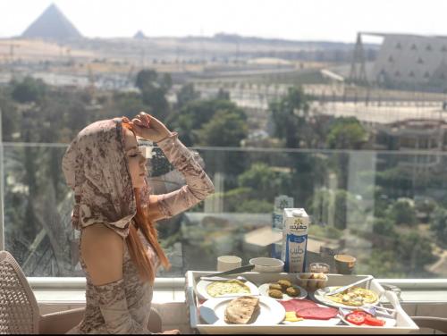 a woman standing in front of a table with food at WOW Pyramids Inn in Cairo
