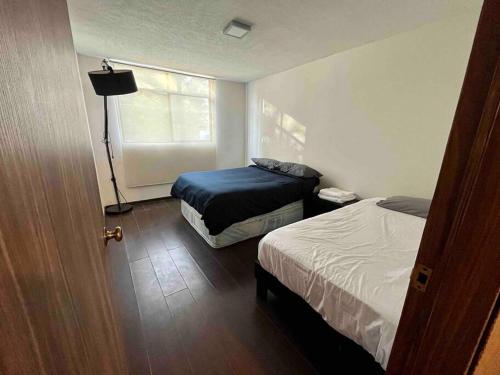 ein kleines Zimmer mit 2 Betten und einem Fenster in der Unterkunft Oasis 101 in El Gallinero
