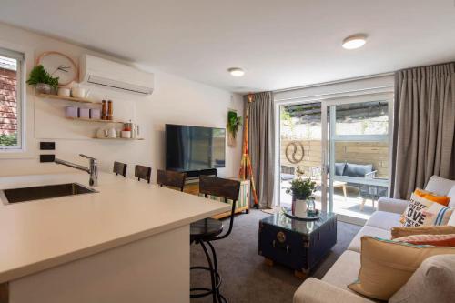a kitchen and living room with a couch and a table at Hillside Villa 2- Walk To Town- AC- Free Parking in Queenstown