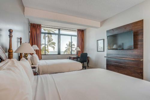 a hotel room with two beds and a flat screen tv at Fort George Hotel and Spa in Belize City
