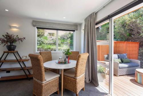 a dining room with a white table and chairs at Hillside Villa 4- Walk To Town- AC- Free Parking in Queenstown