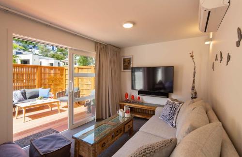 a living room with a couch and a flat screen tv at Hillside Villa 1- Walk To Town- AC- Free Parking in Queenstown