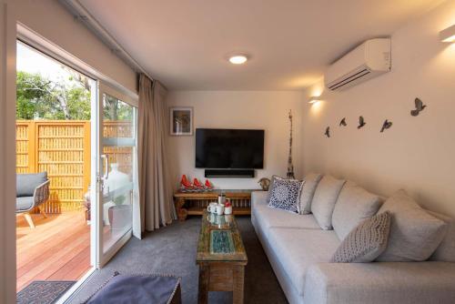 a living room with a couch and a flat screen tv at Hillside Villa 1- Walk To Town- AC- Free Parking in Queenstown