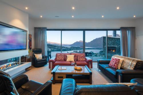 a living room with couches and a flat screen tv at Aurora Lodge- AC- Free Parking- Hot Tub- BBQ in Queenstown