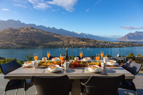 a table with food and a view of a lake at Aurora Lodge- AC- Free Parking- Hot Tub- BBQ in Queenstown