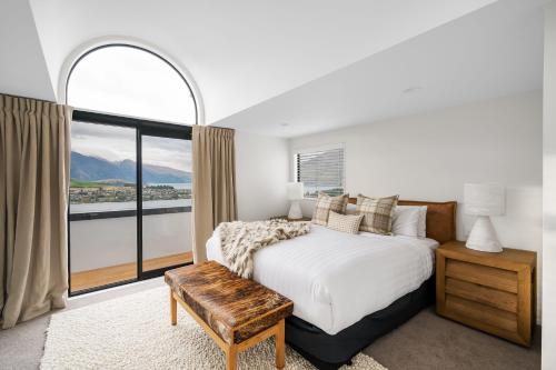 een slaapkamer met een bed en een groot raam bij Karearea- AC- Free Parking- BBQ- Hot Tub in Queenstown