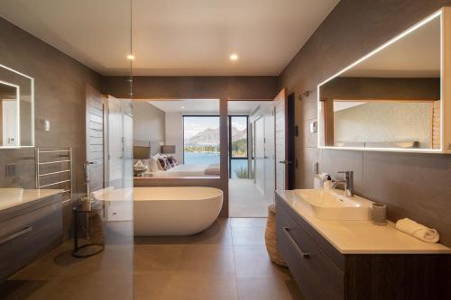 ein Badezimmer mit zwei Waschbecken, einer Badewanne und einer Badewanne in der Unterkunft Lakehouse 1- Free Parking- Walk To Town- Air Con in Queenstown