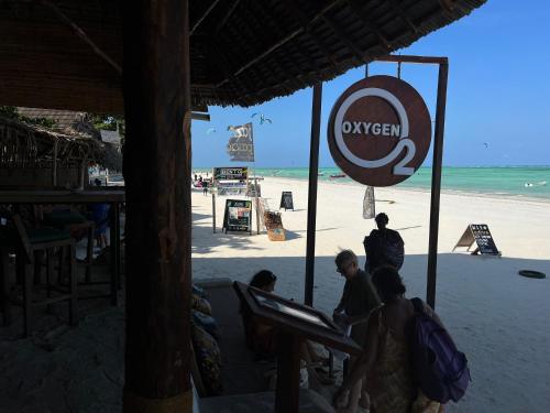 a group of people walking on the beach at Oxygen Paje Hotel in Paje