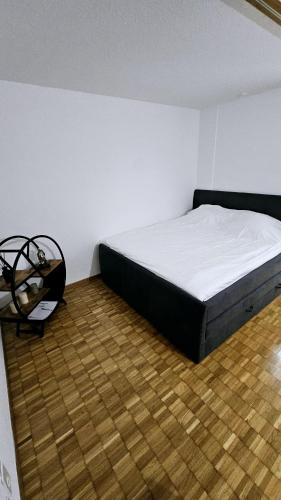- une chambre avec un lit et du parquet dans l'établissement Vintage Apartment NEU, à Unterentfelden