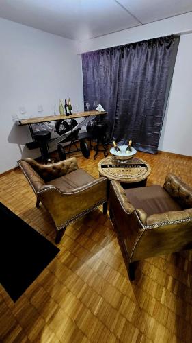 Elle comprend un salon doté d'un mobilier en cuir et d'un piano. dans l'établissement Vintage Apartment NEU, à Unterentfelden