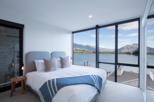 a bedroom with a large bed with a view of the water at Lakehouse 2- Free Parking- Walk To Town- Air Con in Queenstown