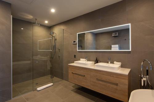a bathroom with two sinks and a shower at Lakehouse 2- Free Parking- Walk To Town- Air Con in Queenstown