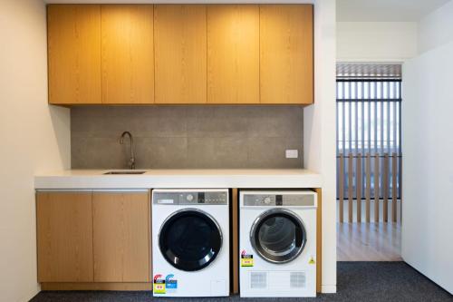 a kitchen with two washing machines and a sink at Lakehouse 2- Free Parking- Walk To Town- Air Con in Queenstown