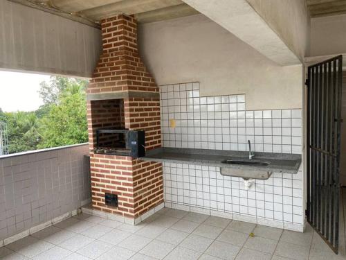 cocina con horno de ladrillo y fregadero en Apartamento em Linhares LocalTOP, en Linhares