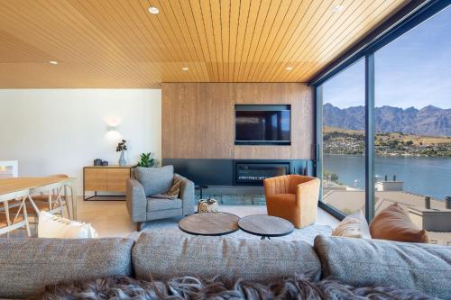 a living room with a large couch and a television at Lakehouse 3- Free Parking- Walk To Town- Air Con in Queenstown