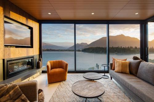 a living room with a couch and a large window at Lakehouse 3- Free Parking- Walk To Town- Air Con in Queenstown