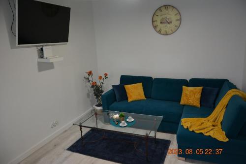 um sofá azul numa sala de estar com um relógio na parede em Apartment near Old Town em Cracóvia