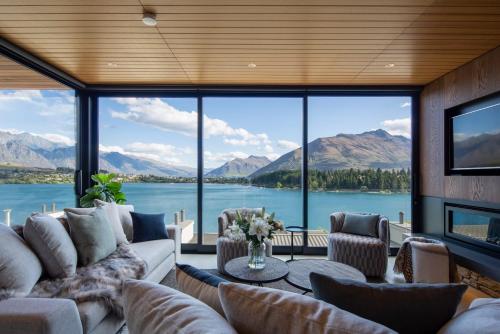 a living room with a view of a lake and mountains at Lakehouse 4- Free Parking- Walk To Town- Air Con in Queenstown