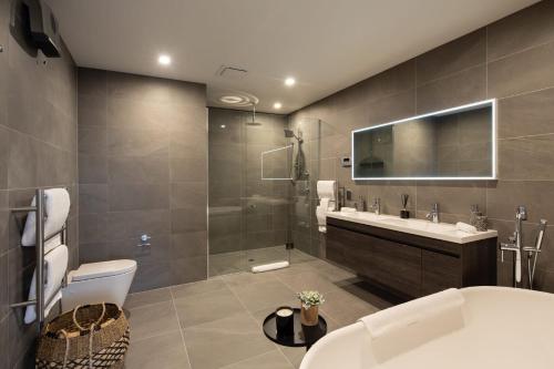 a bathroom with a toilet and a sink and a tub at Lakehouse 4- Free Parking- Walk To Town- Air Con in Queenstown