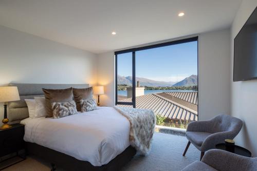 a bedroom with a bed and a large window at Lakehouse 4- Free Parking- Walk To Town- Air Con in Queenstown