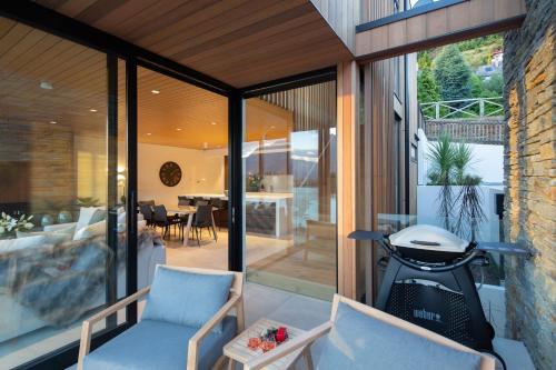 an extension of a house with glass doors and chairs at Lakehouse 4- Free Parking- Walk To Town- Air Con in Queenstown