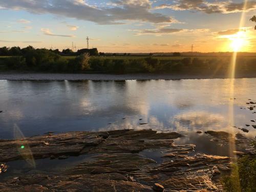 a view of a river with the sun setting at The Coach House in Carlisle