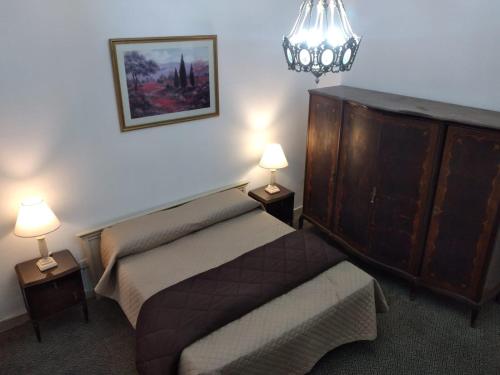 ein Schlafzimmer mit einem Bett, einer Kommode und zwei Lampen in der Unterkunft La Dorada con cochera techada in Rosario