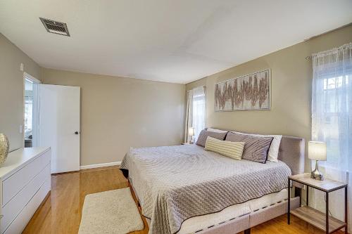 a bedroom with a bed and two windows at Palm Bay Home with Screened Porch - 8 Mi to Beaches! in Palm Bay