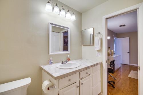 a bathroom with a sink and a mirror and a toilet at Palm Bay Home with Screened Porch - 8 Mi to Beaches! in Palm Bay