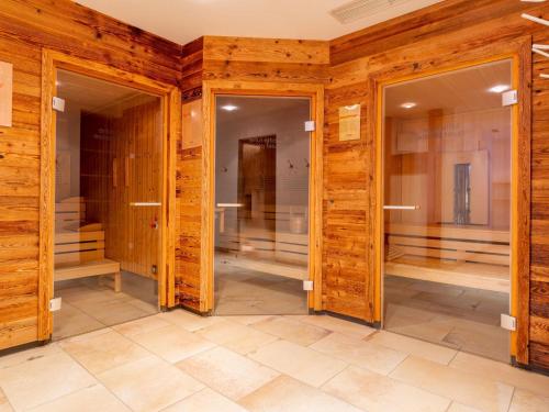 a room with wooden walls and two glass doors at Mountainview in Kaprun