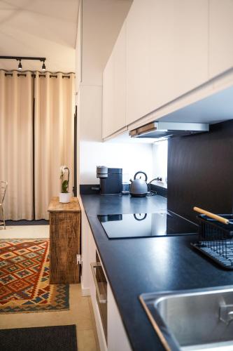 - une cuisine avec un plan de travail noir et un évier dans l'établissement Charming apartment near Notre-Dame, à Paris