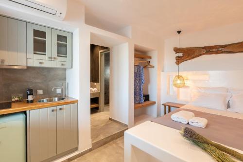 a bedroom with a bed and a kitchen with a sink at Villa Almi in Mykonos in Tourlos