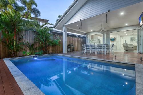 a swimming pool in the backyard of a house at Luxury Retreat on Mudlo, 4 bedroom home with pool in Port Douglas