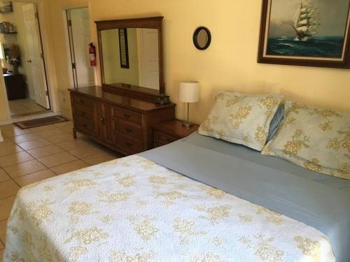 a bedroom with a bed and a dresser and a mirror at Beach, Oceanfront, Flagler Beach Rental in Flagler Beach